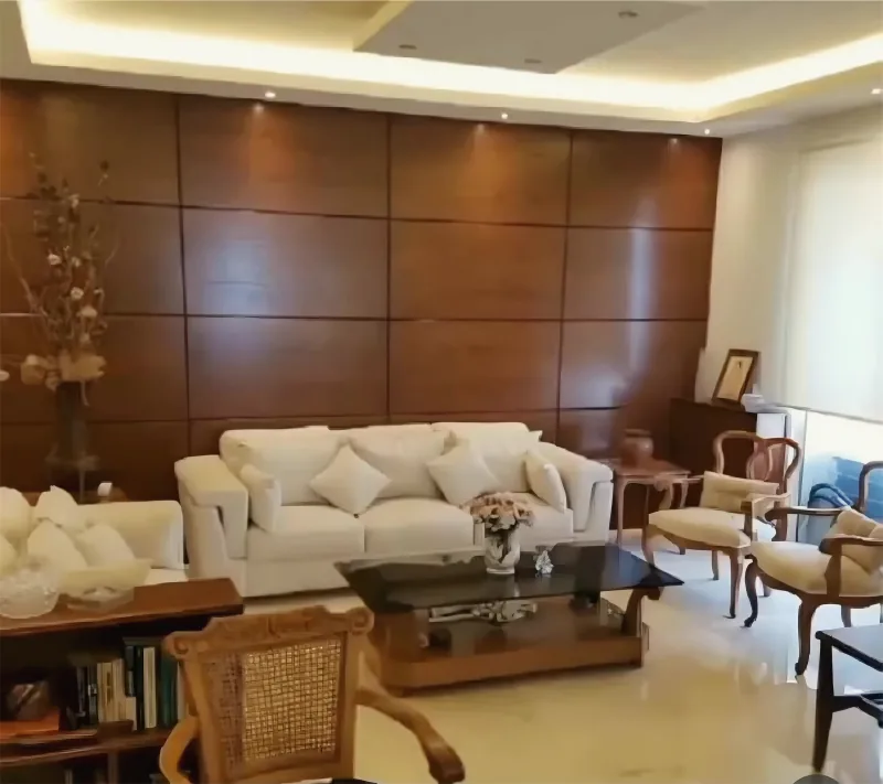 Living room with wood wall panelling and a lit gypsum ceiling, by Yamout
