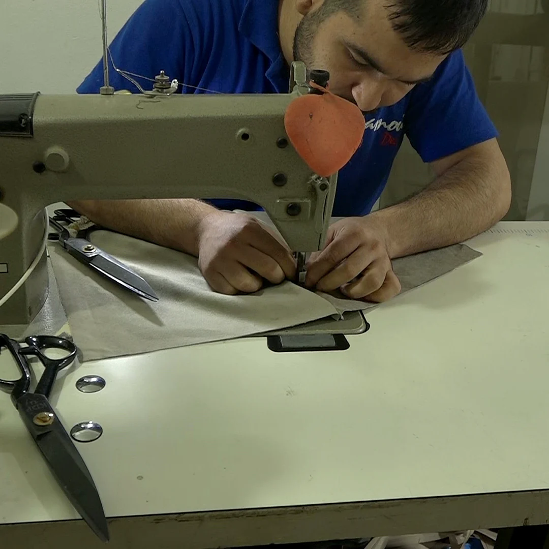 A Yamout upholsterer sewing at the machine in the workshop